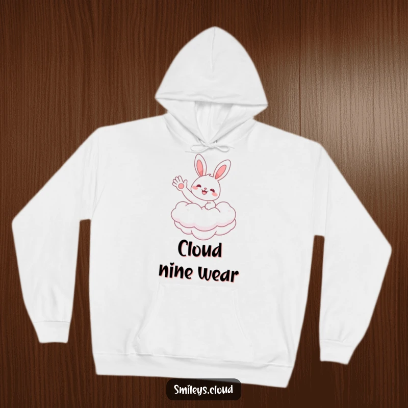 Funny hoodie featuring a cheerful bunny floating on a soft cloud, waving a friendly hello, embodying pure happiness and comfort.